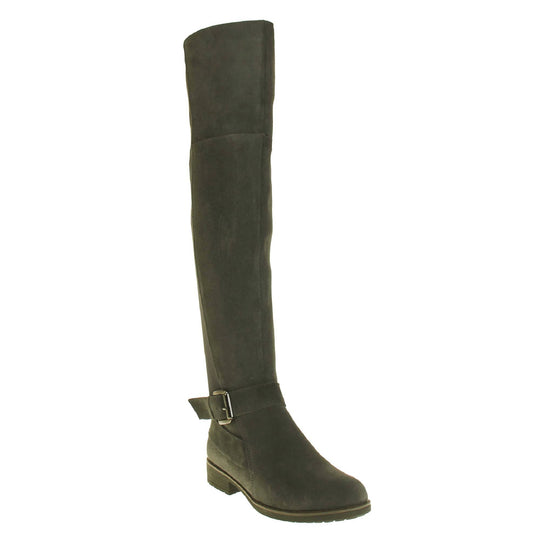 Over the knee grey suede boots. Tall boots that go above the knee in a grey suede upper. Strap with buckle around the ankle. Grey outsole with slight heel. Right foot at an angle.