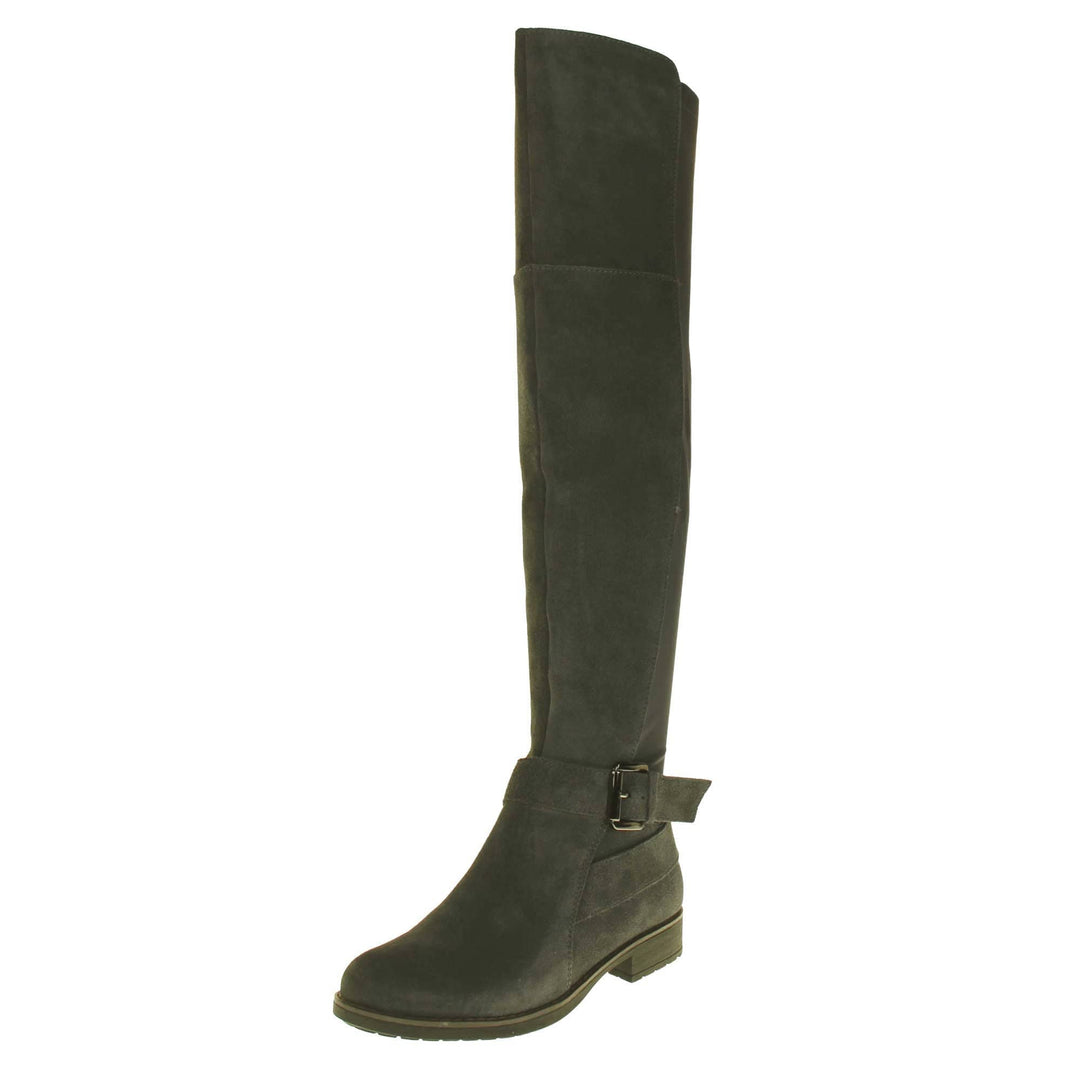 Over the knee grey suede boots. Tall boots that go above the knee in a grey suede upper. Strap with buckle around the ankle. Grey outsole with slight heel. Left foot at an angle.