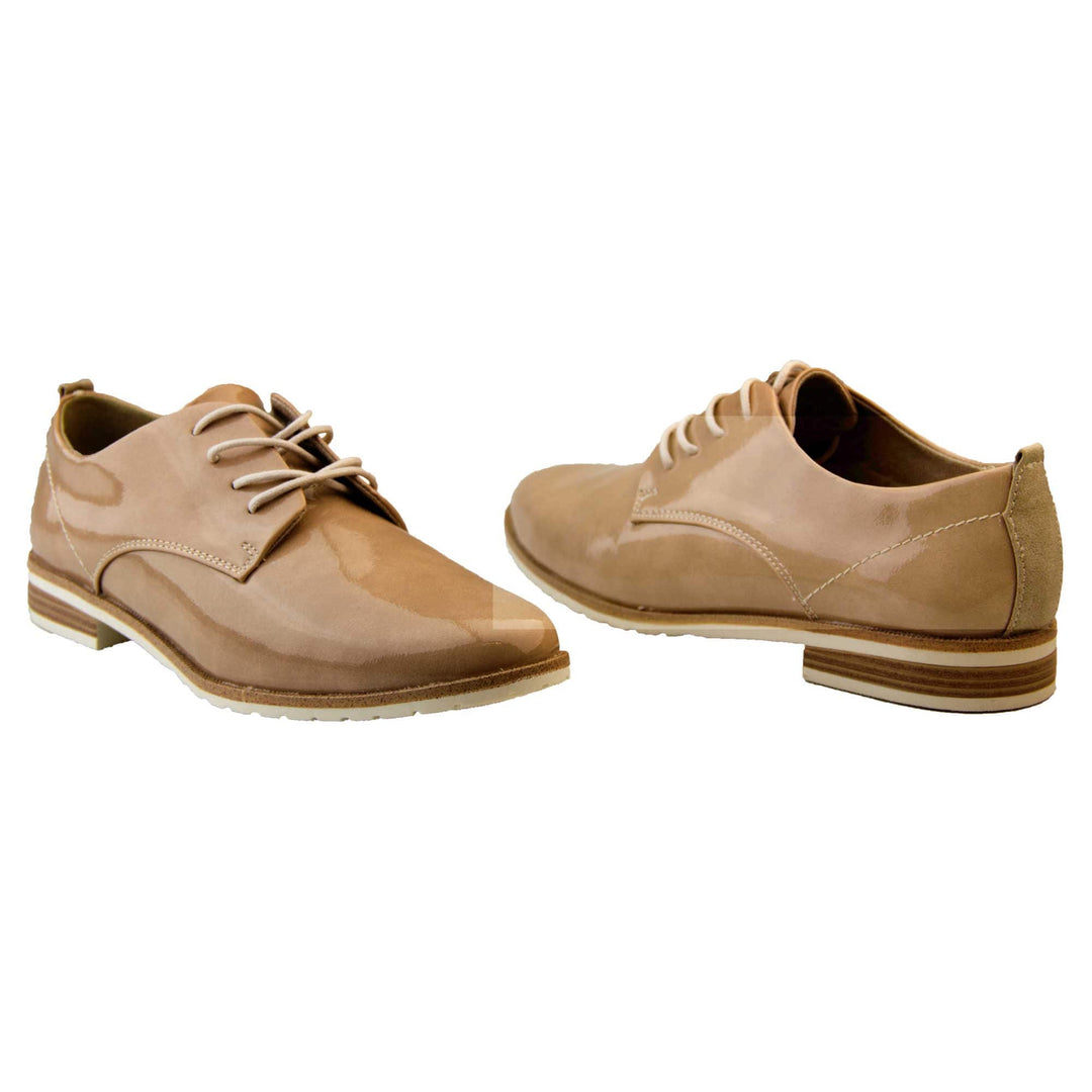 Patent oxfords. Womens oxford style shoes with a nude patent faux leather upper. Stitching detail to the sides. Cream laces and beige lining. Brown and cream sole with a very slight heel. Both feet at an angle facing top to tail.