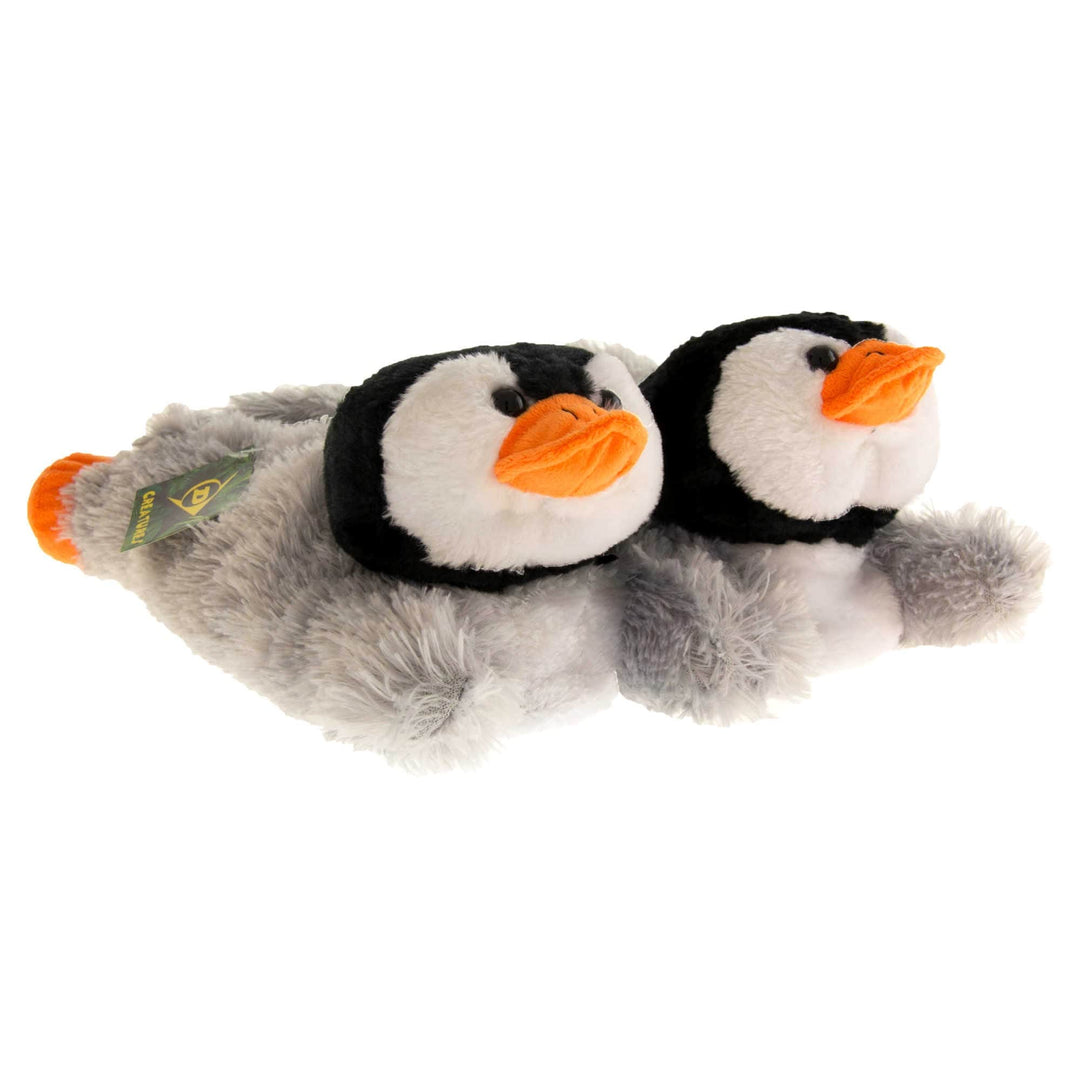 Penguin slippers. Womens padded slippers shaped like a penguin lying on its stomach. With grey faux fur body and black and white fluffy head. Both feet together at an angle.