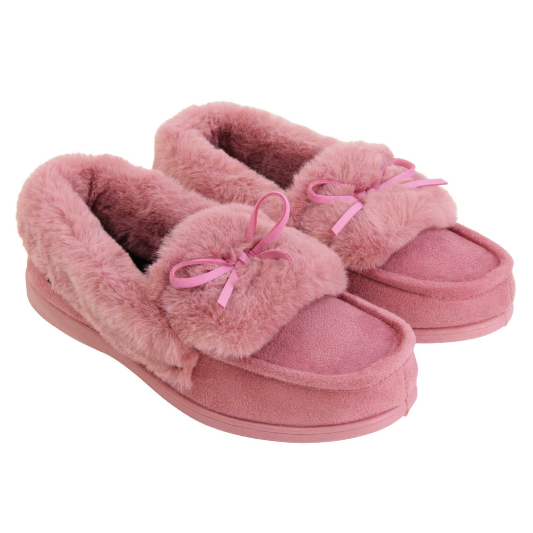 Pink moccasin slippers. Moccasin style slipper with pink faux suede upper and bow to the top. Pink faux fur collar, tongue and lining. Pink rubber sole. Both feet together at an angle.