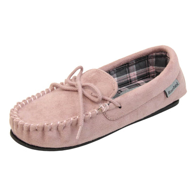 Pink moccasin slippers. Moccasin style slipper with pale pink faux suede upper and rope style bow to the top. Grey Rosebank label to the outside. Pink, grey and white plaid textile lining. Black rubber sole. Left foot at an angle.