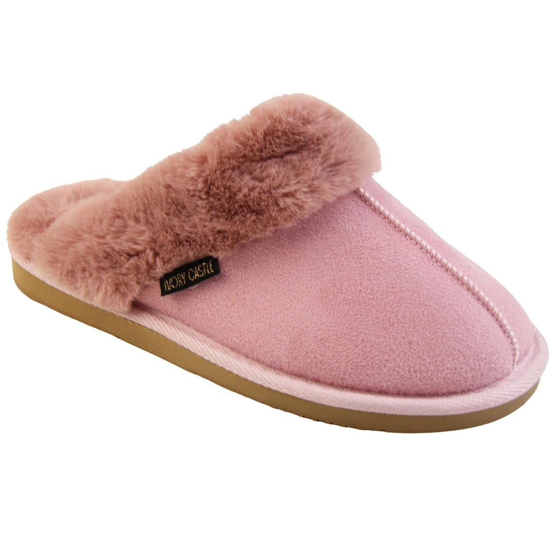 Pink Mule Slippers. Mule style slippers with pink faux suede uppers. Pink faux fur lining and collar. Firm pink outsole with grip on the bottom. Right foot at an angle.