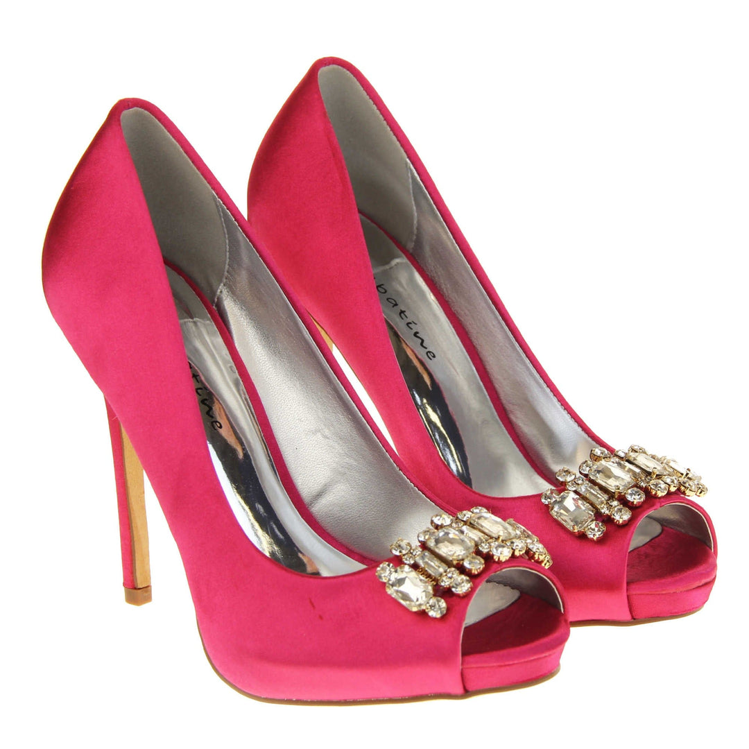 Pink satin wedding shoes. Classic women's peep toe high heels with a fuchsia satin upper. Metallic silver insole with Sabatine branding. Fuchsia satin stiletto heel with a cream sole. Diamante cluster detailing across the toes. Both feet together at a slight angle.