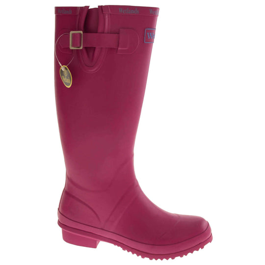 Pink wellington boots. Bright pink rubber waterproof wellington boots. Just below knee height. With a small heel and deep tread to the sole. Pink Wetlands Brand to the front of the boot near the top. Wetlands written in Lilac numerous times around the rim of the boot. Side strap with buckle to adjust the calf width. Textile lining to the inside of the boot. Right foot at an angle.