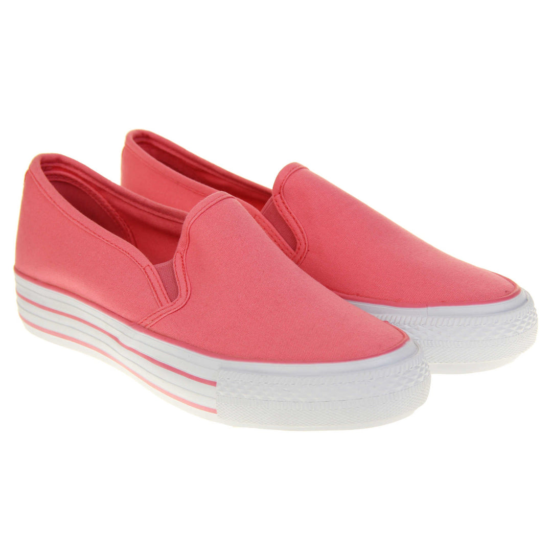 Platform pumps. Slip on plimsoll style shoes with a pink canvas upper. Pink elasticated gusset. White flat platform sole with two pink lines running around the middle. Both feet together at a slight angle.
