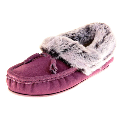 Purple slippers womens. Ladies plum faux suede moccasin style slippers. With stitched detailing and tassels with subtle glitter on. Pale grey faux fur collar and lining with a pale lilac hint. Purple firm sole. Left foot at an angle.