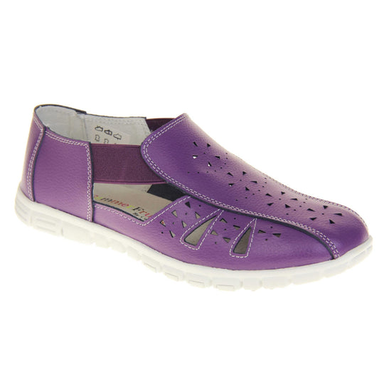 Purple wide fit shoes. Womens classic full foot sandal with a purple leather upper. Strappy sides with cut out designs along the side and centre straps. Purple elasticated straps joining the centre to the backs. White insole and leather lining. White sole with grip to the bottom. Right foot at an angle.