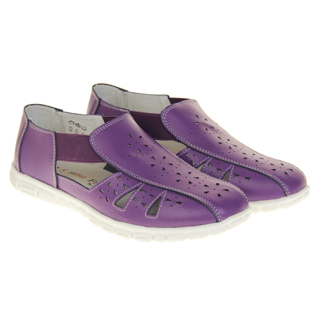 Purple wide fit shoes. Womens classic full foot sandal with a purple leather upper. Strappy sides with cut out designs along the side and centre straps. Purple elasticated straps joining the centre to the backs. White insole and leather lining. White sole with grip to the bottom. Both shoes together from an angle