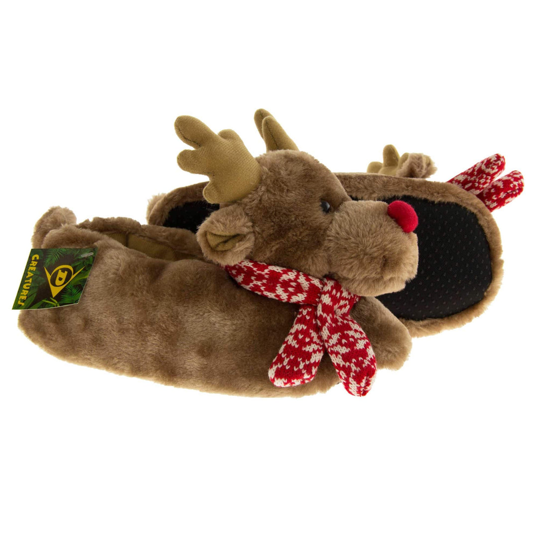 Reindeer slippers womens . Womens padded slippers shaped like a reindeer. With brown faux fur body and head. With light brown antlers, a red nose and a red and white knit scarf. Both feet from a side profile with the left foot on its side behind the the right foot to show the sole.