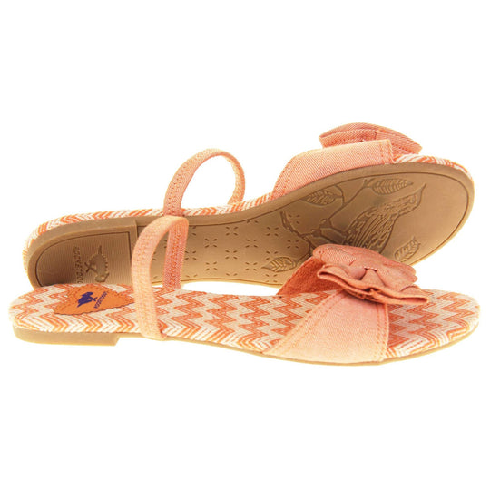 Rocket dog sandals. Classic womens slingback sandals with a orange coral coloured textile straps. orange and cream zig zag print insoles with an orange heart to the bag with Rocket dog logo. Thin beige outsole with a tiny heel. Right foot side on with left foot outsole showing.