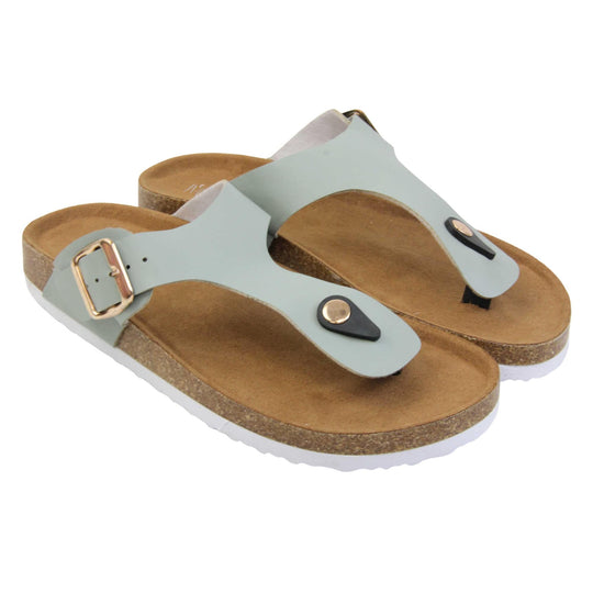Sage flip flops. Sage green faux leather strap with toe post to the front and gold buckle to the outside. Soft tan faux suede footbed with cork effect outsole and white sole. Both feet together at a slight angle.