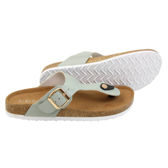 Sage flip flops. Sage green faux leather strap with toe post to the front and gold buckle to the outside. Soft tan faux suede footbed with cork effect outsole and white sole. Both feet from a side profile with the left foot on its side behind the the right foot to show the sole.
