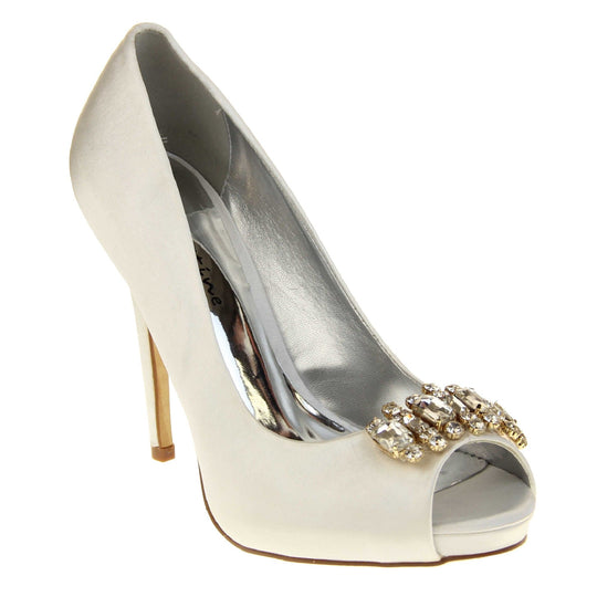 Satin bridal shoes. Classic women's peep toe high heels with an ivory satin upper. Metallic silver insole with Sabatine branding. Ivory satin stiletto heel with a cream sole. Diamante cluster detailing across the toes. Right foot at an angle.