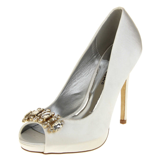 Satin bridal shoes. Classic women's peep toe high heels with an ivory satin upper. Metallic silver insole with Sabatine branding. Ivory satin stiletto heel with a cream sole. Diamante cluster detailing across the toes. Left foot at an angle.