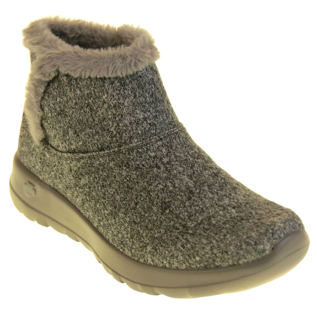 Skechers Boots UK. Grey wool blend boots. With grey faux fur collar and side edging. Grey chunky synthetic rubber sole with weave effect grip to the bottom. Grey faux fur lining inside the boot. Right foot at an angle