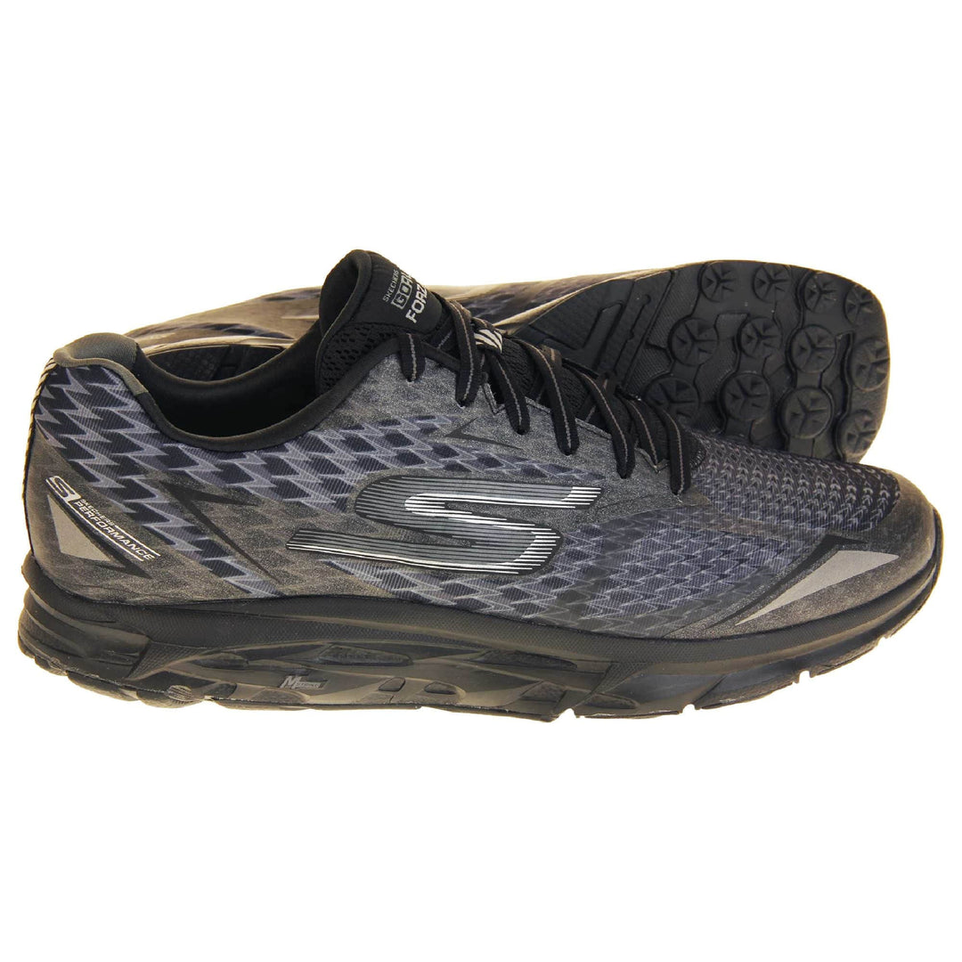 Skechers go run mens. Black mesh upper. Black and grey laces and black textile lining. Grey and white Skechers logo to the side and chunky black outsole with grip. Both feet from a side profile with the left foot on its side to show the sole.