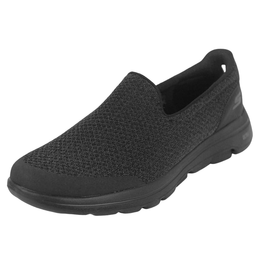 Skechers go walk five. Mens loafer style shoes with a trainer sole. Black woven mesh upper. Skechers S logo to the back. Black sole with grip to the bottom. Black textile lining. Left foot at an angle.