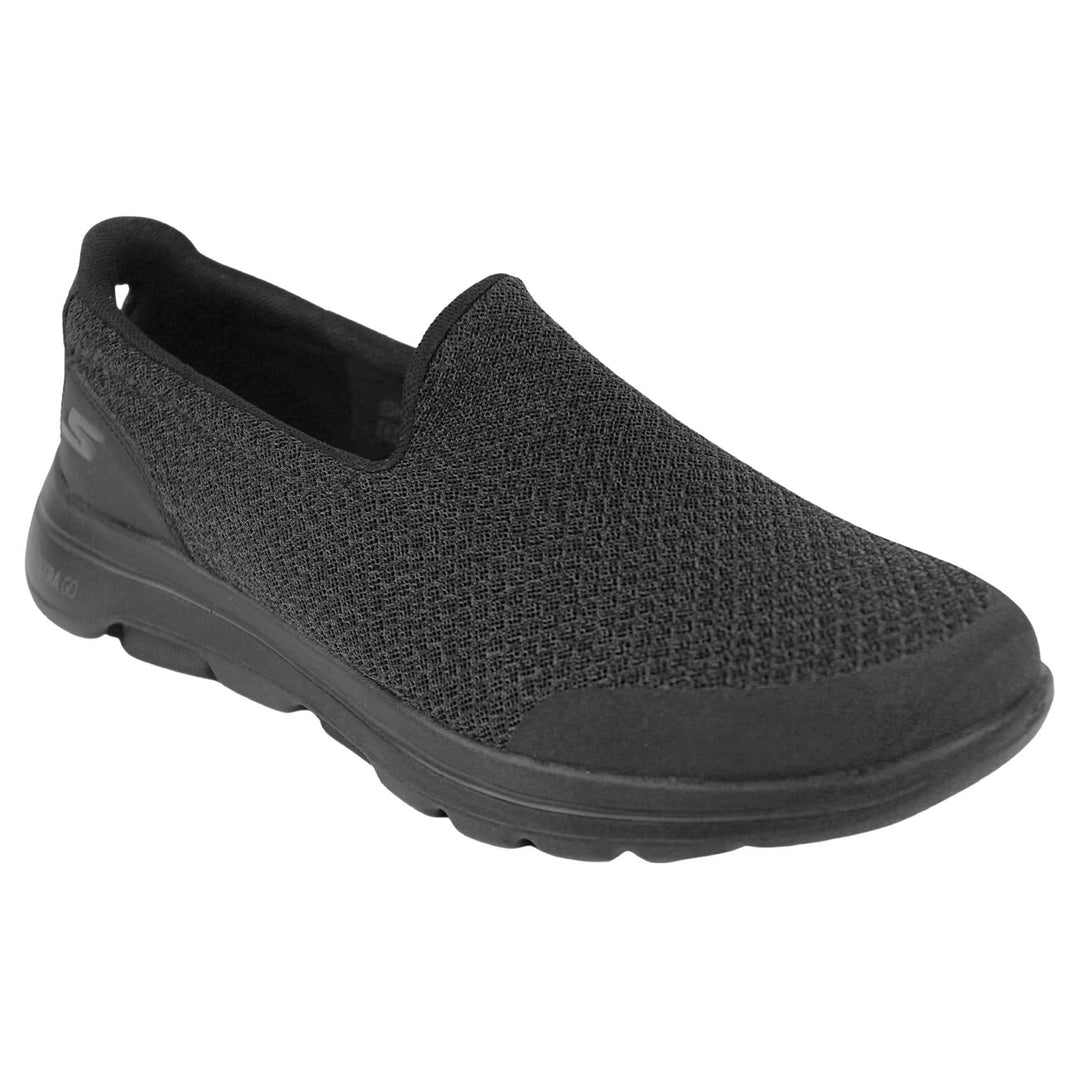 Skechers go walk five. Mens loafer style shoes with a trainer sole. Black woven mesh upper. Skechers S logo to the back. Black sole with grip to the bottom. Black textile lining. Right foot at an angle.