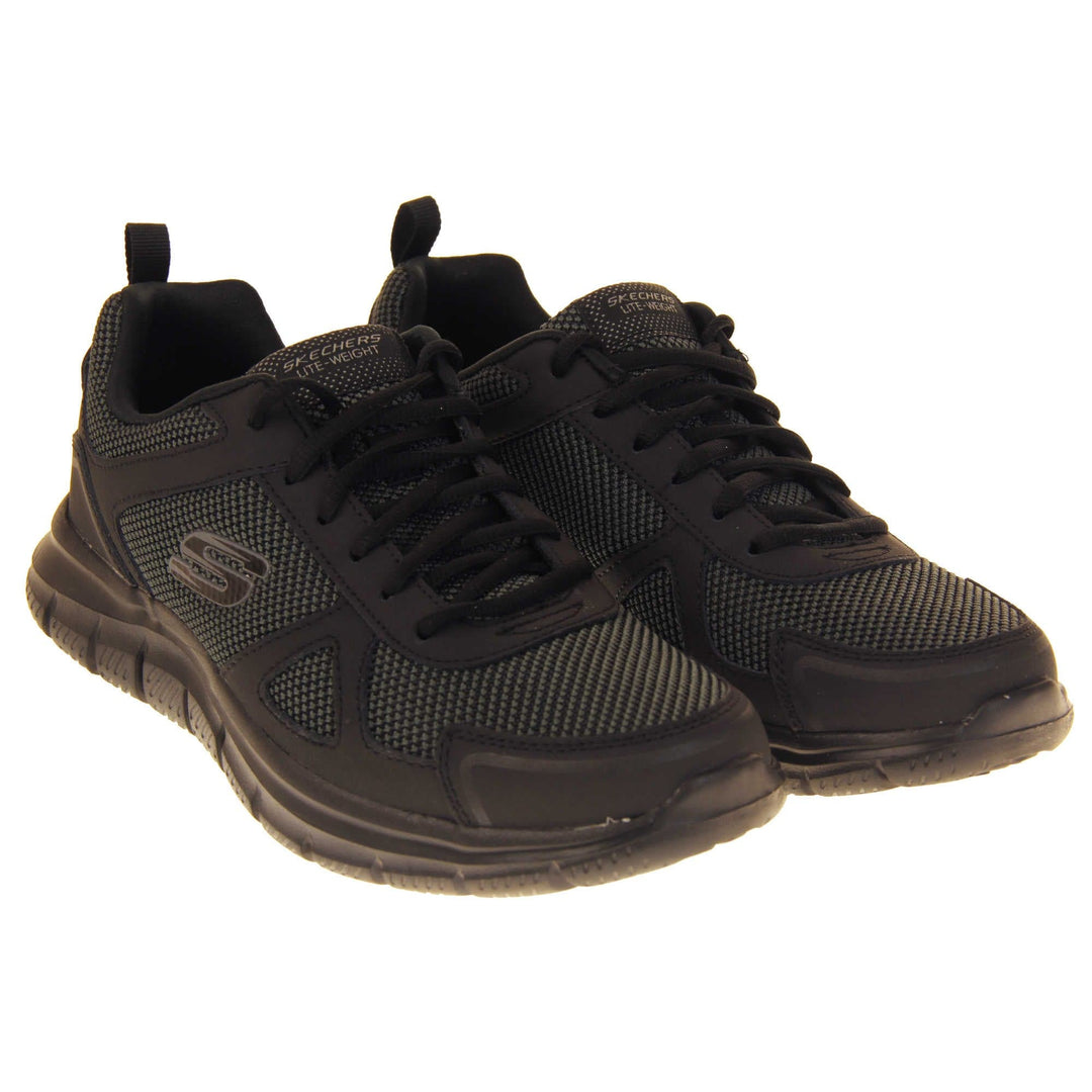 Skecher light weight. Black mesh and leather upper with black laces and black textile lining. Grey and black Skechers logo to the side and chunky black outsole with grip. Both shoes together at an angle.