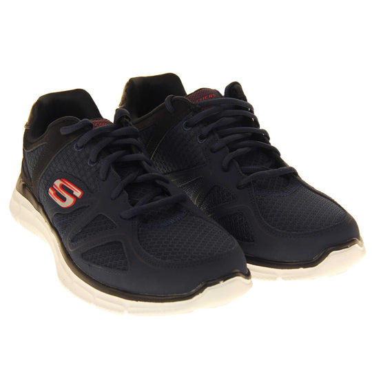 Skechers mens trainers Navy blue mesh and leather upper with black leather accents to the back. Navy laces and black textile lining. Red and white Skechers logo to the side and chunky white outsole with grip. Both shoes together at an angle.