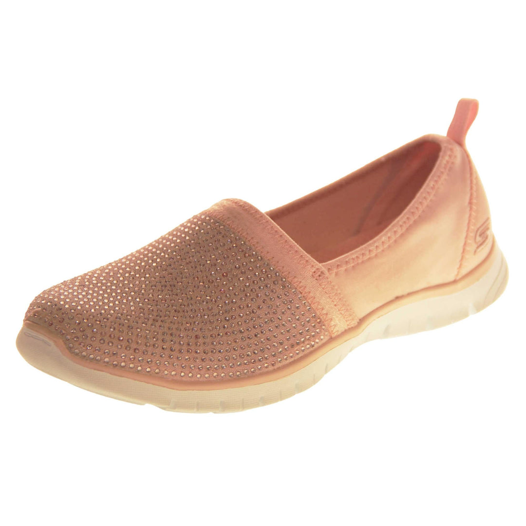 Skechers Shoes Pink. Rose gold lycra ladies flats. Front half of the shoe, toe to mid foot, is covered in pale pink rhinestones. Skechers logo and branding to the back of the shoe. White synthetic sole. Left foot at an angle