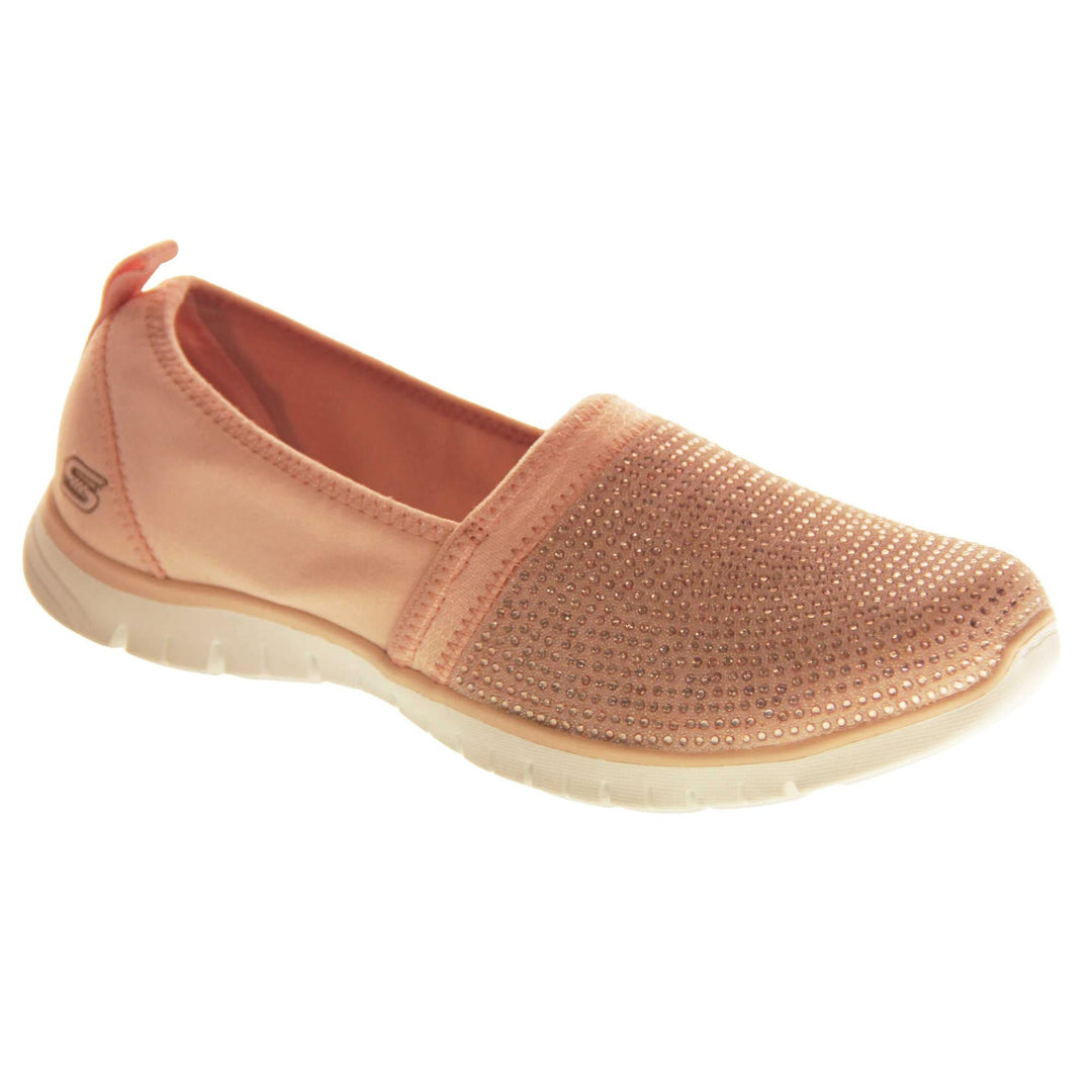 Skechers Shoes Pink. Rose gold lycra ladies flats. Front half of the shoe, toe to mid foot, is covered in pale pink rhinestones. Skechers logo and branding to the back of the shoe. White synthetic sole. Right foot at an angle