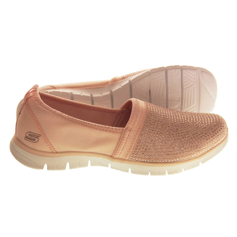 Skechers Shoes Pink. Rose gold lycra ladies flats. Front half of the shoe, toe to mid foot, is covered in pale pink rhinestones. Skechers logo and branding to the back of the shoe. White synthetic sole. Both shoes from side profile, with left shoe on its side to show the sole.