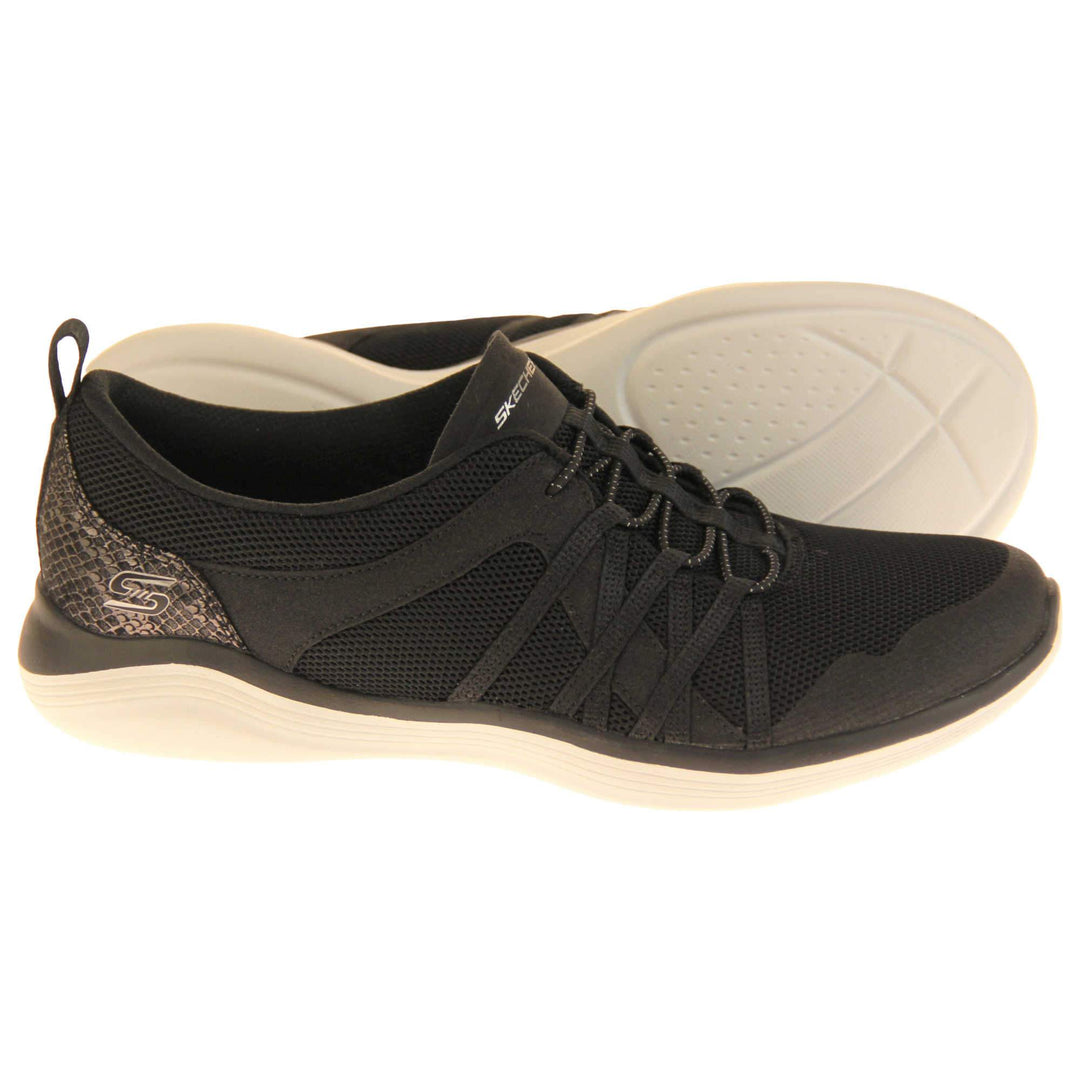 Skechers slip on trainers. Trainers with a black mesh upper. Black glitter banding to the side and up to the laces. Faux snakeskin heel panel with Skechers logo on. Black bungee laces with which lines on. Skechers in grey on the tongue. Black fabric lining. White synthetic sole. Both feet from a side profile with left foot on its side to show the sole.