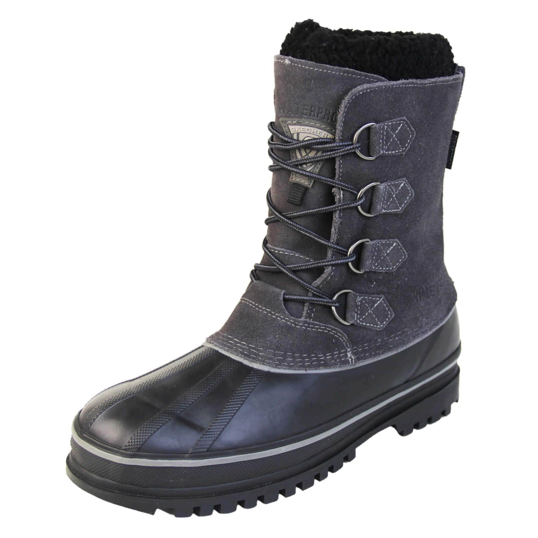 Skechers waterproof boots. Black high ankle boots with a waterproof suede upper and high traction rubber outsole. Elastic faux laces to the front with Skechers branding to the tongue. Black fleecy collar and Thinsulate lining inside the boot. The chunky sole has a grey line running all the way around the top. Left foot at an angle.