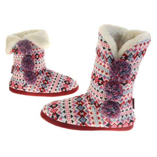 Slipper boots with hard sole. Multi coloured patterned knit upper in a Scandinavian or Aztec style with pom poms to the side, light beige plush faux fur trim and lining. Both feet from the side to show the outside of the foot.