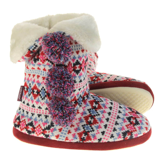 Slipper boots with hard sole. Multi coloured patterned knit upper in a Scandinavian or Aztec style with pom poms to the side, light beige plush faux fur trim and lining.  Both feet from a side profile with the left foot on its side behind the the right foot to show the sole.