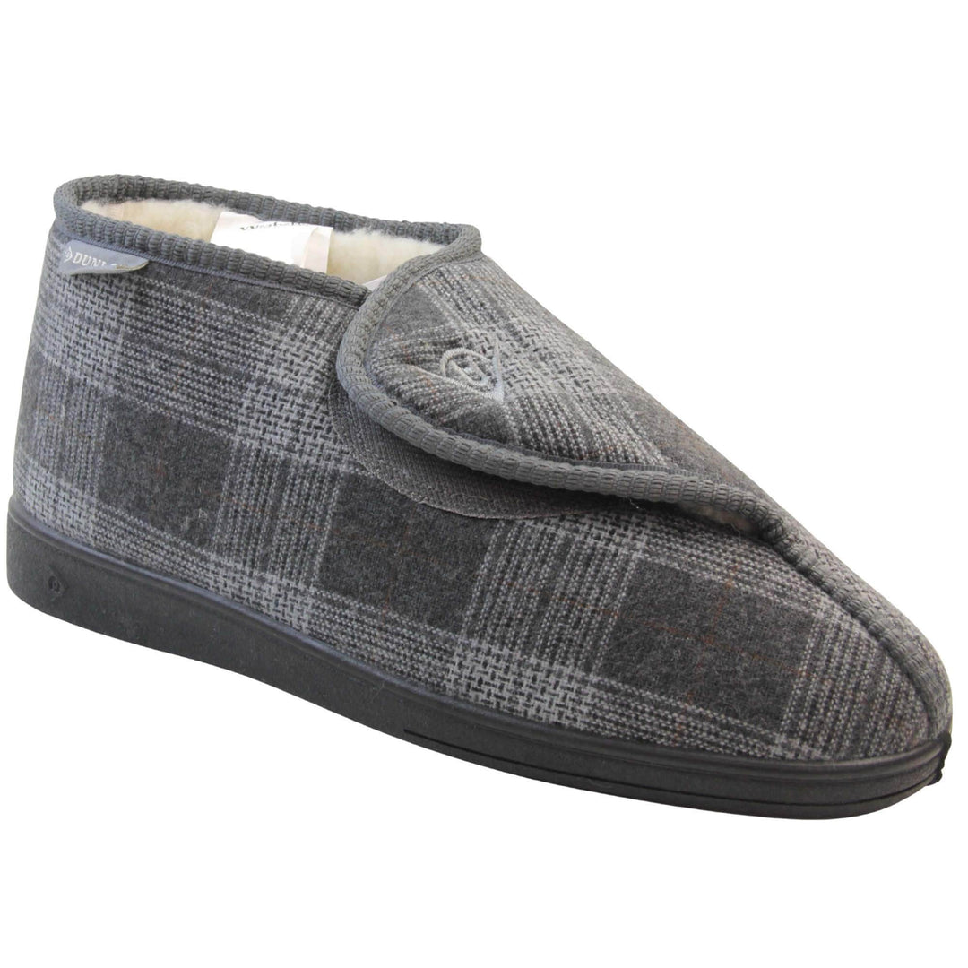Orthopaedic slippers. Mens orthopaedic slippers in an ankle boot style. With a grey plaid upper and white fleece lining. With an adjustable touch close top with a grey Dunlop logo on. Small grey label to the outer side edge with Dunlop written on. Thick black outdoor sole. Right foot at an angle.