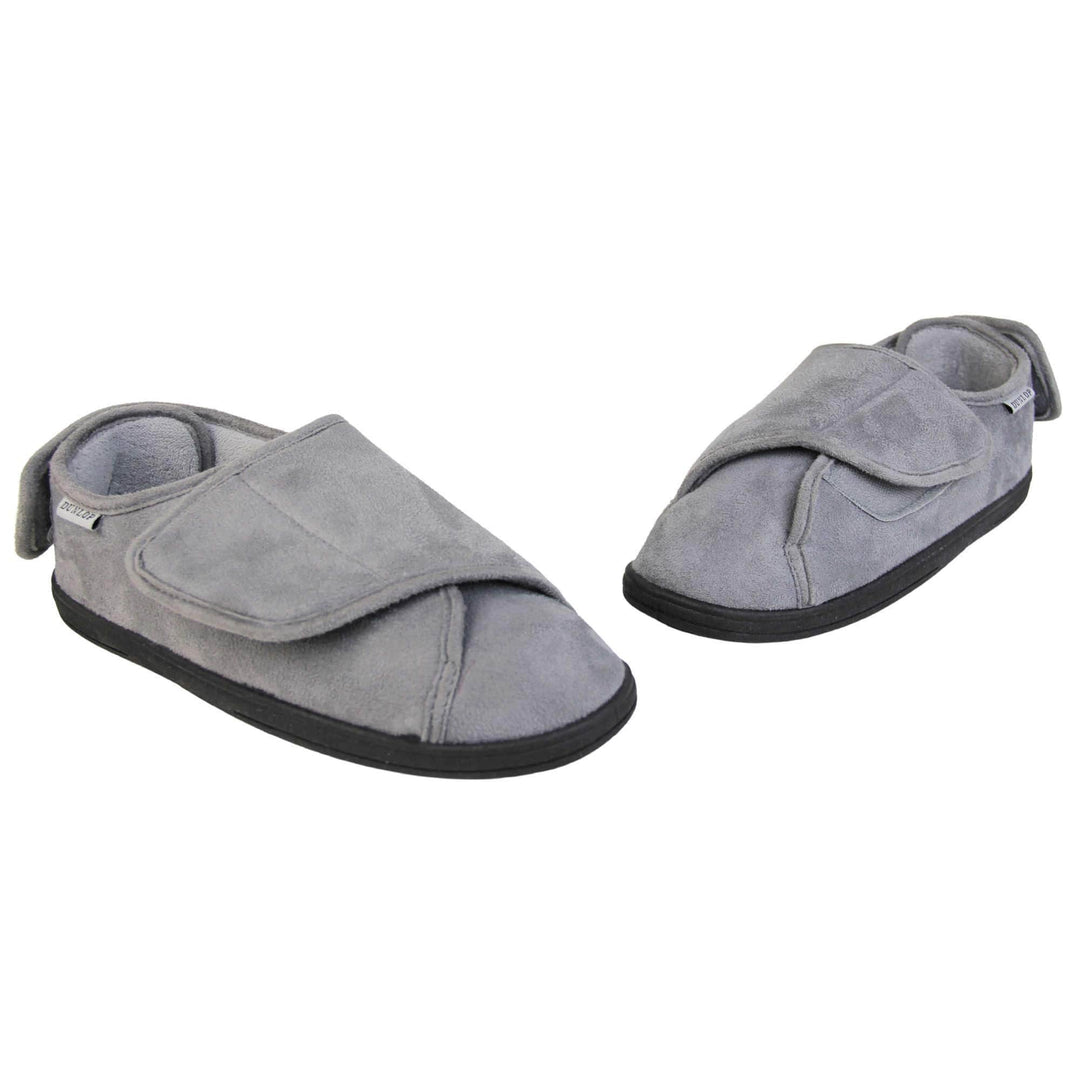 Mens adjustable slippers. Full back slippers with grey upper. Adjustable touch fasten strap to the top of the foot and around the back of the heel. Small white label on the outside rim, with Dunlop branding sewn in black. Grey faux fur lining. Firm black sole. Both shoes is a V shape with toes forming the point. 