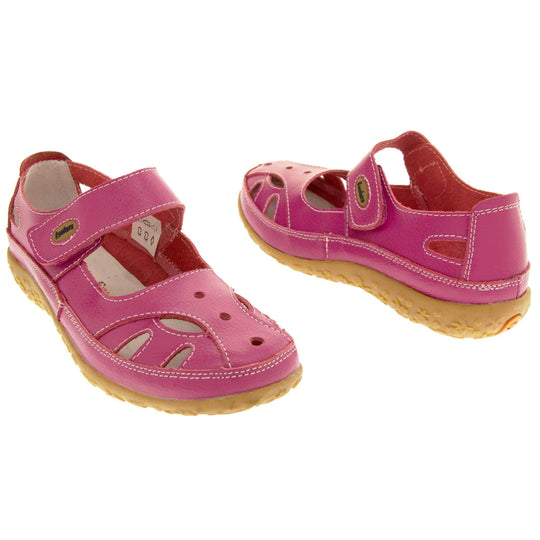 Soft leather shoes. Mary Jane style shoes. Pink leather uppers with white stitching detail. Pink touch fasten strap over the foot with brown oval, where it fastens, with Coolers logo in the centre. Cut outs in the middle, edges and heel of the shoes. Brown synthetic soles with flower design grips. Both shoes about an inch apart at a slight angle facing top to tail.