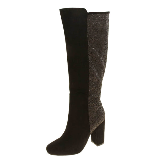 Sparkly knee high boots. Black faux suede upper with the back half of the boot covered in black glitter. Zip fastening down the inside leg of the boot. With a black block high heel and black sole. Left foot at an angle.