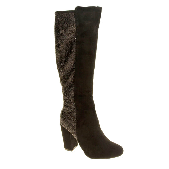 Sparkly knee high boots. Black faux suede upper with the back half of the boot covered in black glitter. Zip fastening down the inside leg of the boot. With a black block high heel and black sole. Right foot at an angle.