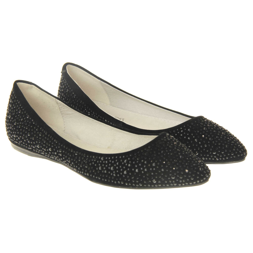 Sparkly shoes flat. Ballet style shoes with a black faux suede upper covered in black diamantes. Cream leather lining and black sole. Both feet together at a slight angle.