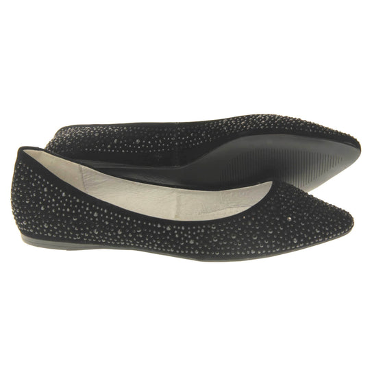 Sparkly shoes flat. Ballet style shoes with a black faux suede upper covered in black diamantes. Cream leather lining and black sole. Both feet from a side profile with the left foot on its side behind the the right foot to show the sole.