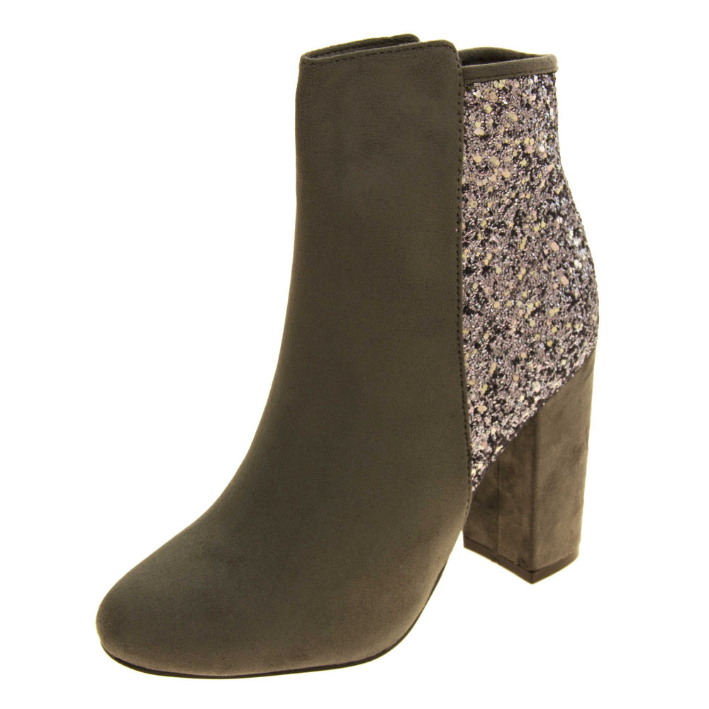 Suede ankle boots women. Grey faux suede upper with the back half of the boot covered in silver glitter. Zip fastening down the inside leg of the boot. With a grey block high heel and black sole. Left foot at an angle.