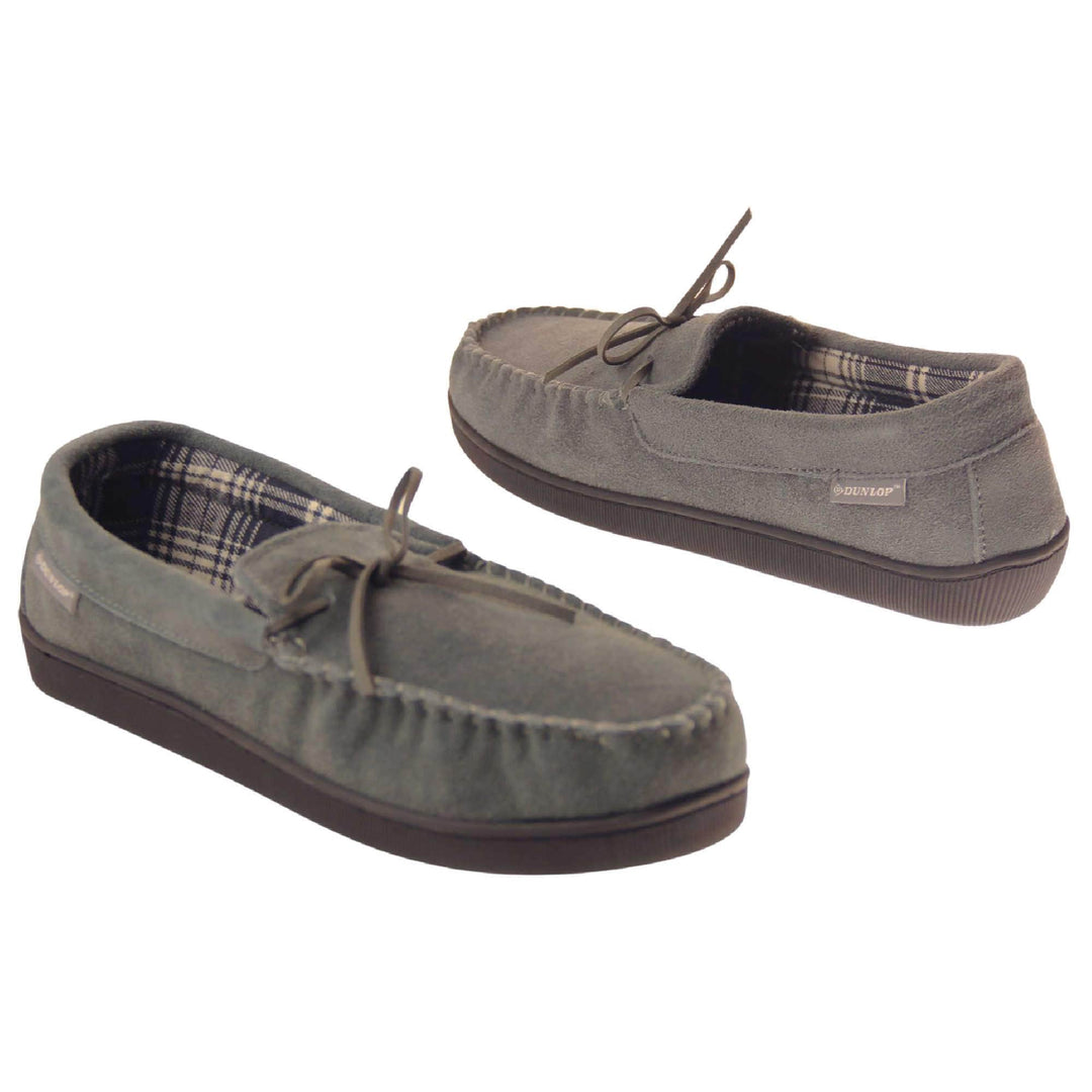 Suede moccasin slippers. Moccasin style slipper with grey suede upper and leather bow to the top. Grey Dunlop label to the outside. Grey and white plaid textile lining. Black rubber sole. Both shoes spaced apart, facing top to tail at an angle.