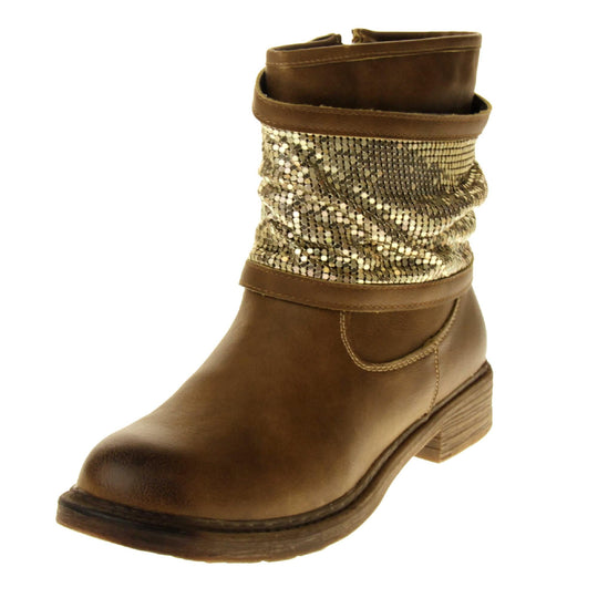 Tan sparkle ankle boots women. Biker style ankle boot with a tan faux leather upper. A thick band of shiny gold chainmail runs around the ankle. Zip fastening down the inside of the boot. Brown sole with a slight heel. Left foot at an angle.
