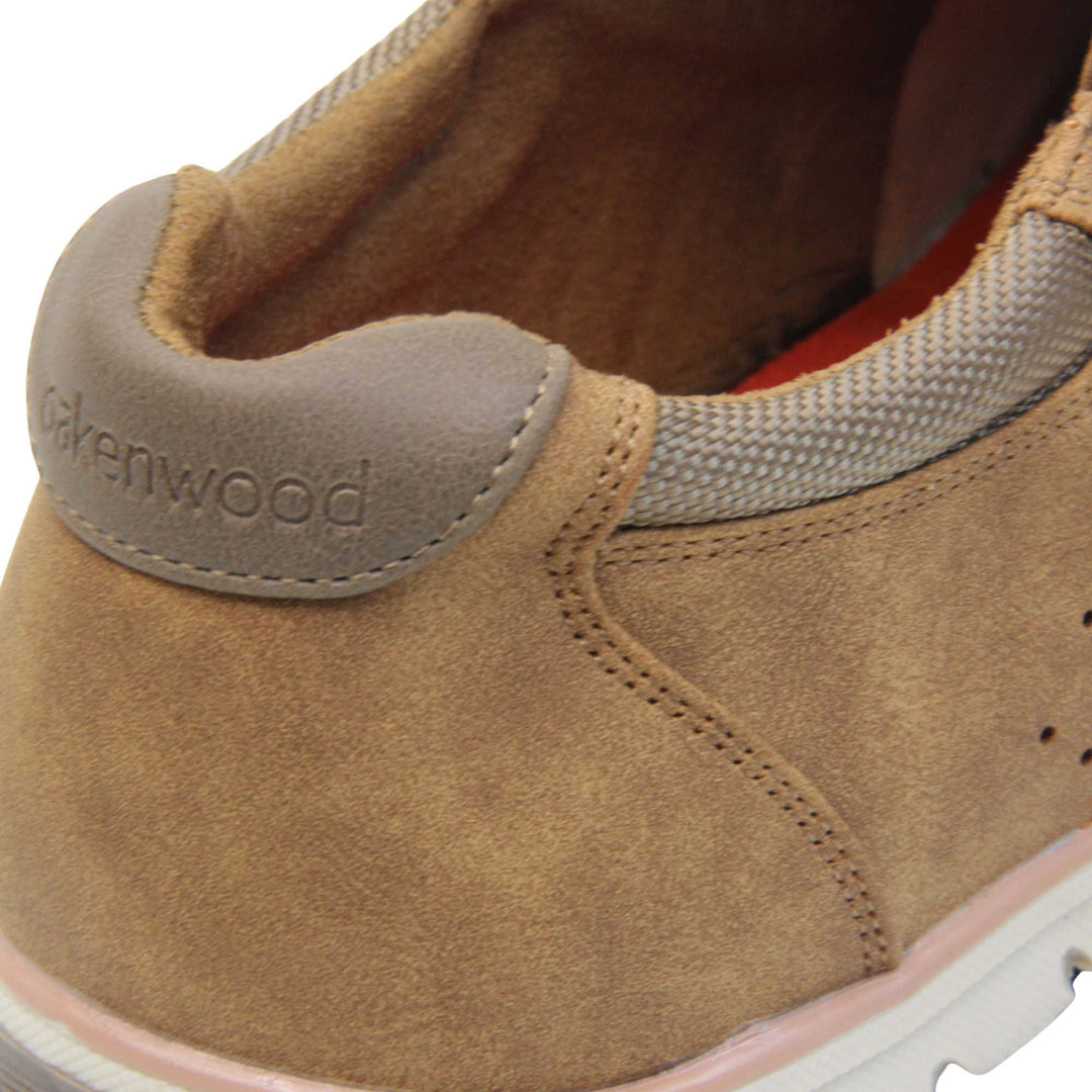 Tan trainers mens. Slip on trainers with tan faux suede uppers. Elasticated side gussets in brown and a dark brown diagonal stripe to the side of the shoe. Brown collar around the neck of the shoe with Oakenwood branding to the heel. Tan lining and a white outsole with grey sole. Left foot close up of the heel of the shoe to show the lining and heel branding of the shoe.