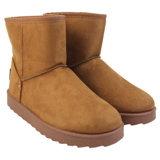 Tan winter boots women's. Ankle boots with a tan faux suede upper and stitching detail. Brown faux fur lining. Chunky brown sole with deep tread to the bottom. Both feet together from an angle.