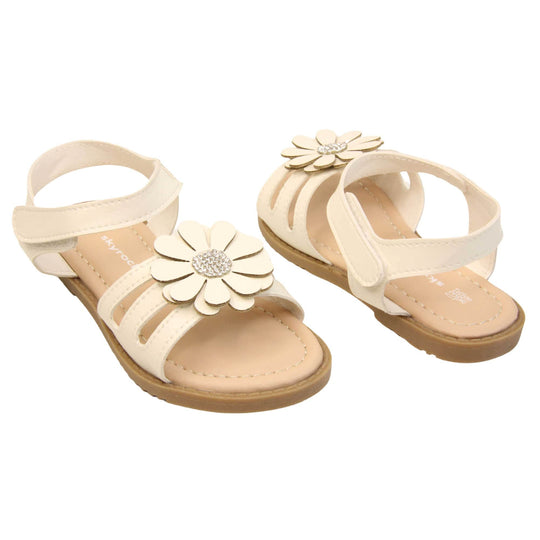 Toddler girl flower sandal. Strappy sandals with white faux leather strappy upper. With around the ankle strap with hook and loop fastening. White flower detailing to the front of the shoe with a diamante middle. Beige coloured insole with Skyrocket branding in white. Brown sole with grip to the bottom. Both feet at an angle facing top to tail.