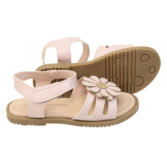Toddler shoes girl. Strappy sandals with pale pink faux leather strappy upper. With around the ankle strap with hook and loop fastening. Pink flower detailing to the front of the shoe with a diamante middle. Beige coloured insole with Skyrocket branding in brown. Brown sole with grip to the bottom. Both feet from a side profile with the left foot on its side behind the the right foot to show the sole.