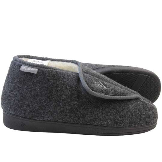 Orthopaedic slippers. Mens orthopaedic slippers in an ankle boot style. With a grey felt upper and white fleece lining. With an adjustable touch close top with a grey Dunlop logo on. Small grey label to the outer side edge with Dunlop written on. Thick black outdoor sole. Both feet from side profile with the left foot on its side to show the sole.