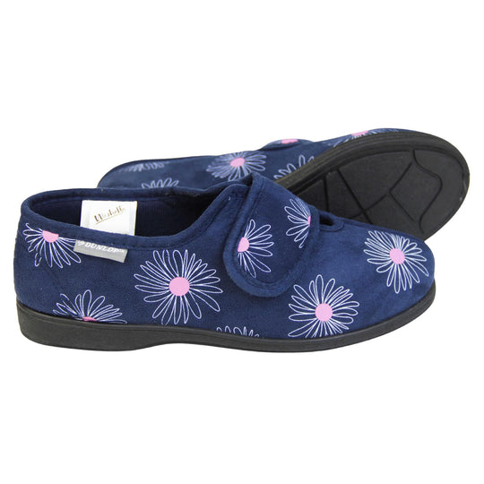 Washable slippers womens. Ladies full back slipper. Navy blue upper with white daisy design and bright pink for the middle of the flowers. Touch fasten strap over the top of the foot to adjust the fit. Matching blue textile lining and sole. Both feet from a side profile with the left foot on its side behind the the right foot to show the sole.