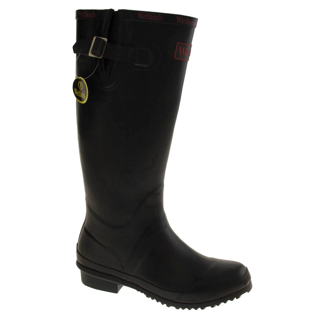 Womens Wellies. Black rubber waterproof wellington boots. Just below knee height. With a small heel and deep tread to the sole. Red Wetlands Brand to the front of the boot near the top. Wetlands written in red numerous times around the rim of the boot. Side strap with buckle to adjust the calf width. Textile lining to the inside of the boot. Right foot at an angle.