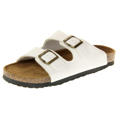 White flat sandals womens. Ladies dual strap slip on sandals. With a white synthetic leather upper with a gold buckle on each strap. Brown faux suede insole with a moulded footbed. Cork effect outsole with black base with grip to the bottom. Left foot at an angle.